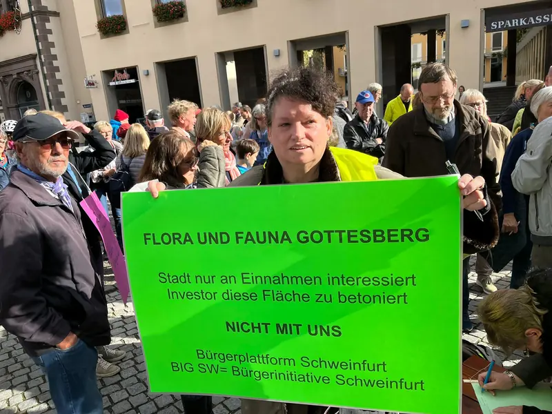 Demonstrierende mit einem grünen Plakat: Flora und Fauna Gottesberg – Stadt nur an Einnahmen interessiert, Investor diese Fläche zu betoniert – nicht mit uns